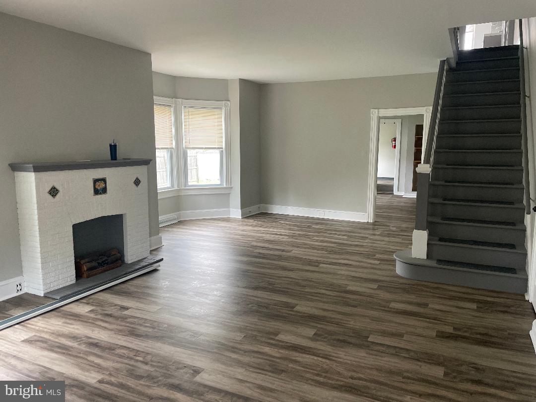 246 West Front Street Florence, NJ 08518 - Photo 2 of 9 a view of an empty room with wooden floor fireplace and a window