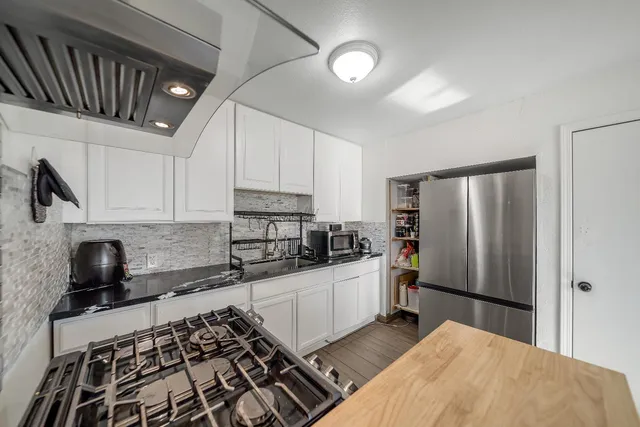 a kitchen with stainless steel appliances a refrigerator a sink a stove a microwave and cabinets