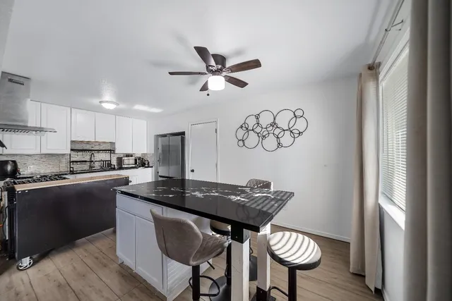 a kitchen with stainless steel appliances granite countertop a stove a sink dishwasher and a refrigerator with wooden floor