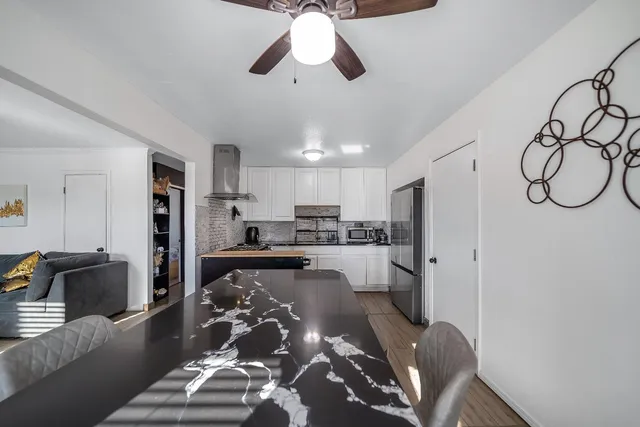 a large kitchen with a table chairs refrigerator and microwave