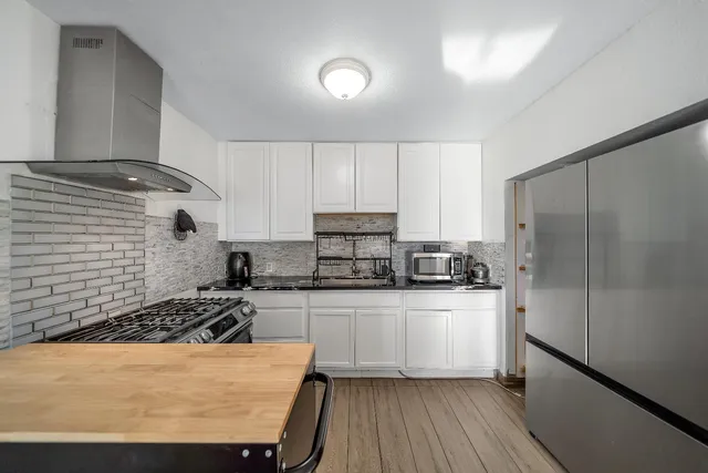 a kitchen with stainless steel appliances granite countertop a sink stove refrigerator and cabinets