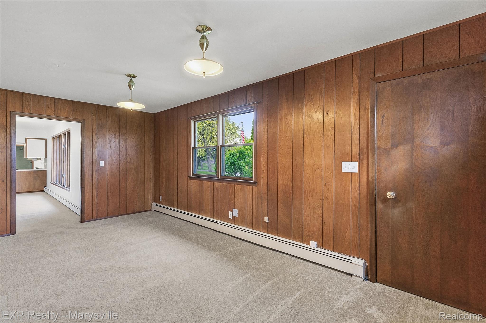 3345 Beach Road Port Huron, MI 48060 - Photo 11 of 89 Spare room with a baseboard radiator, light carpet, baseboard heating, and wood walls