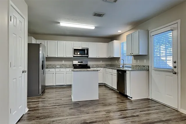 a kitchen with white cabinets stainless steel appliances and sink