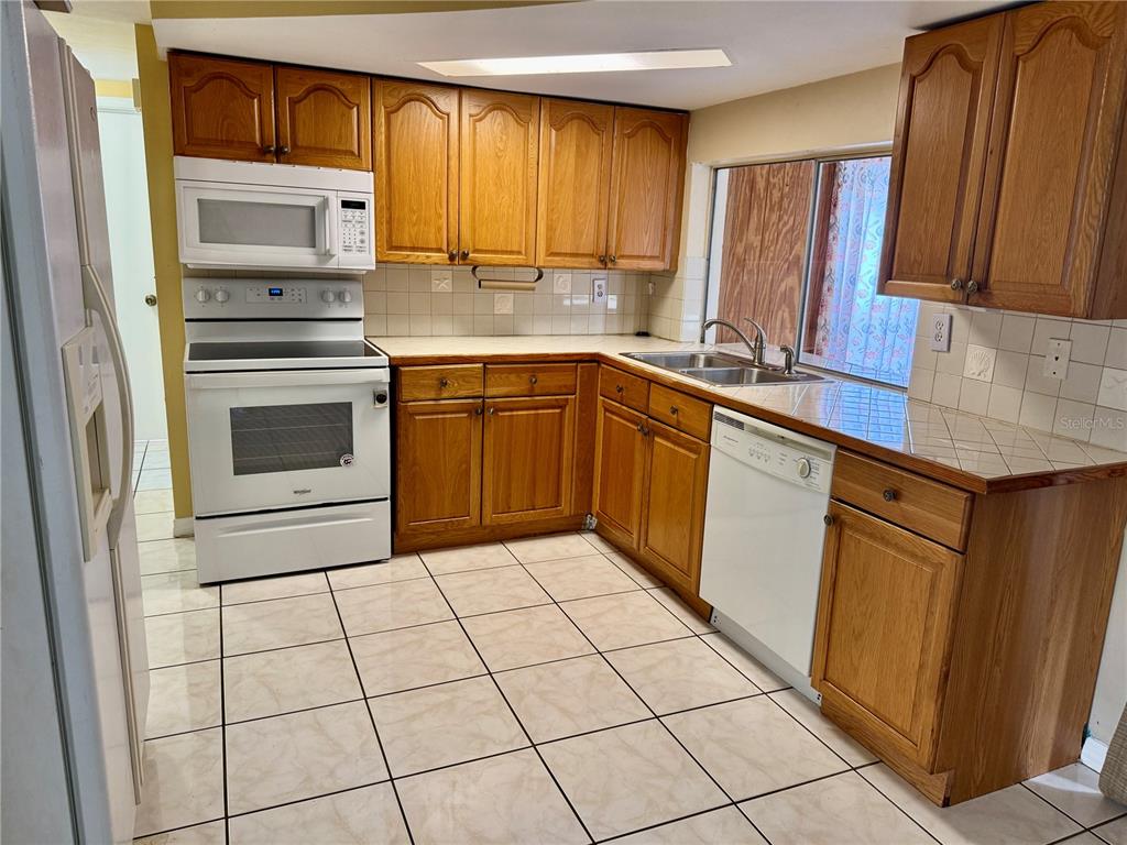 3049 Moog Road Holiday, FL 34691 - Photo 6 of 19 a kitchen with a stove a sink and a microwave