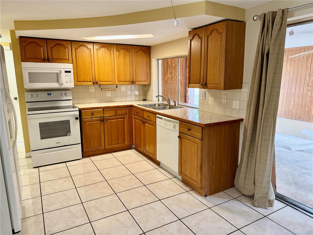 3049 Moog Road Holiday, FL 34691 - Photo 7 of 19 a kitchen with stainless steel appliances a sink cabinets and a window