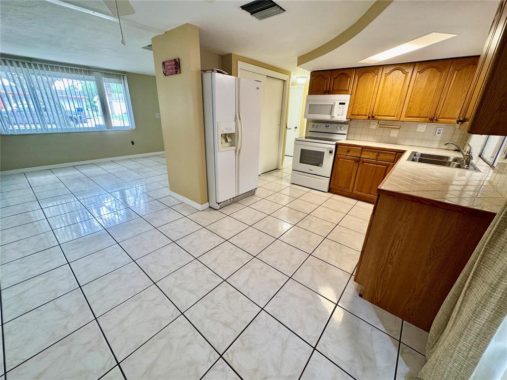 3049 Moog Road Holiday, FL 34691 - Photo 8 of 19 a kitchen with stainless steel appliances a refrigerator sink and cabinets