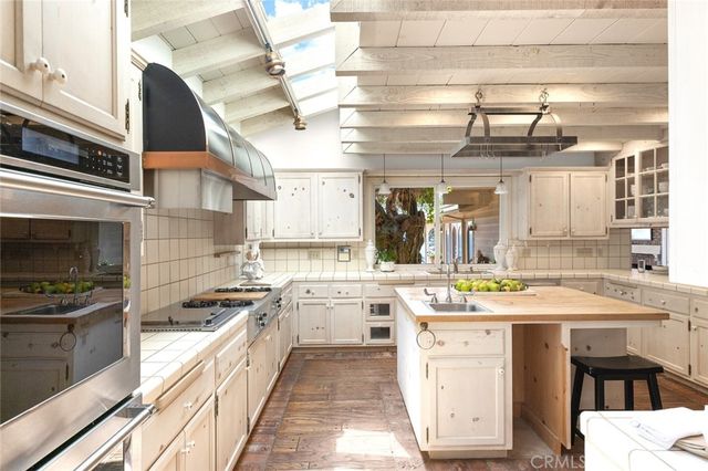 a kitchen with a stove a sink and cabinets