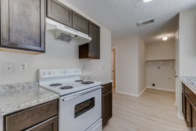 a kitchen with granite countertop a stove and a sink