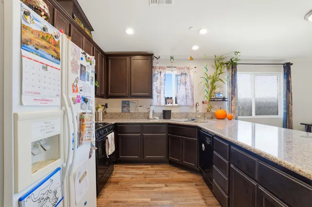 a kitchen with stainless steel appliances granite countertop a refrigerator and a sink