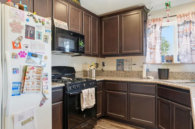 a kitchen with stainless steel appliances granite countertop a stove a sink and a microwave