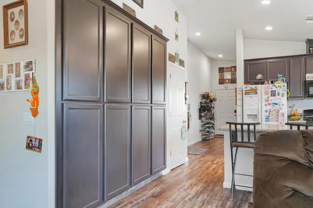 a view of kitchen with stainless steel appliances refrigerator wooden floor and wooden floor