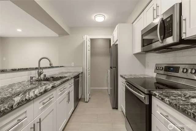 a kitchen with stainless steel appliances granite countertop a sink stove and refrigerator