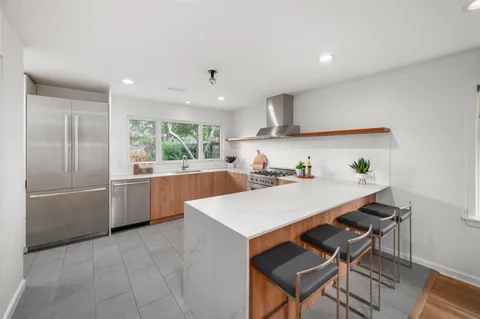 a kitchen with a table chairs a barbeque oven and dining table