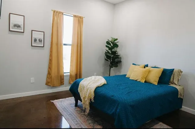 a bed sitting in a bedroom next to a window