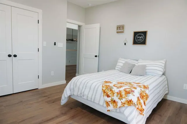 a bedroom with a bed and wooden floor