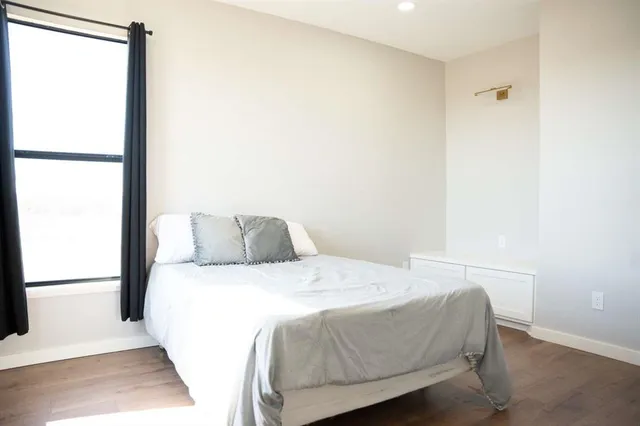 a bed sitting in a bedroom next to a window