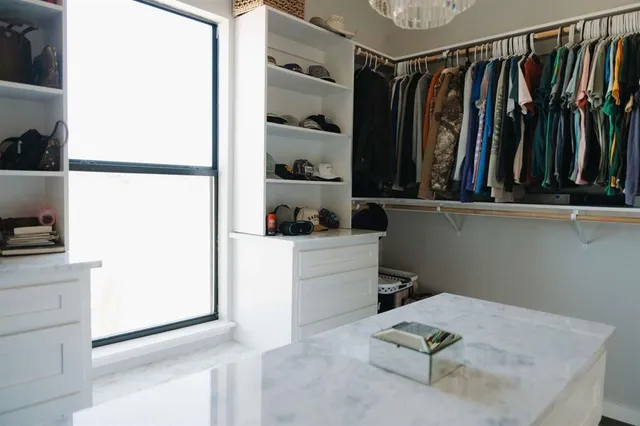 a view of walk in closet with clothes and shoes