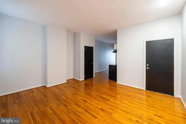 a view of an empty room with wooden floor