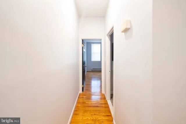a view of a hallway with wooden floor