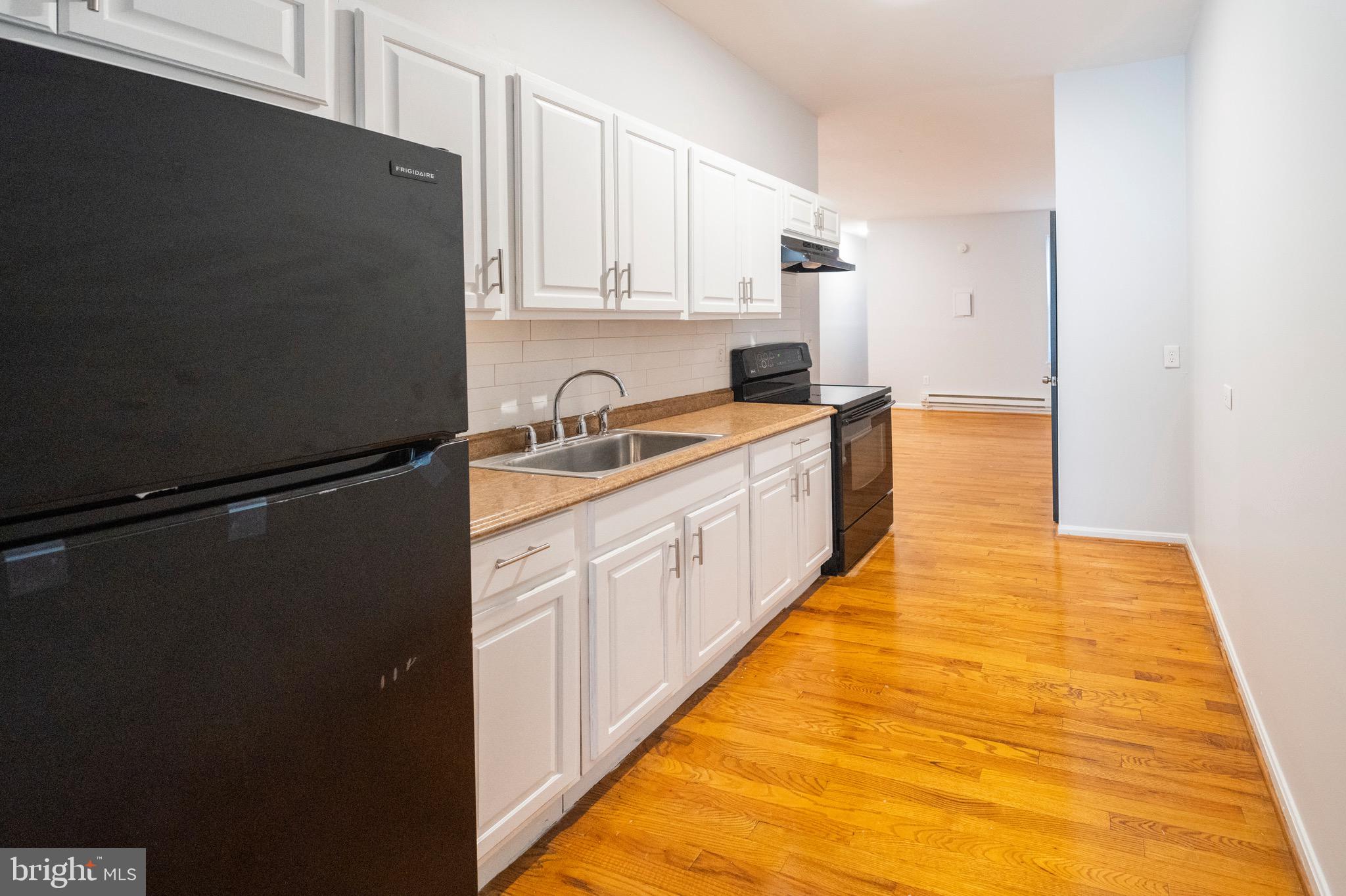 812 Newington Avenue Baltimore, MD 21217 - Photo 24 of 38 a large kitchen with a sink and refrigerator