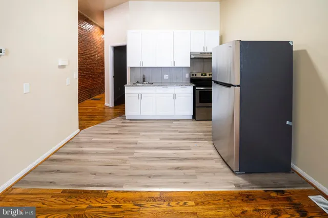 a view of kitchen cabinets and refrigerator