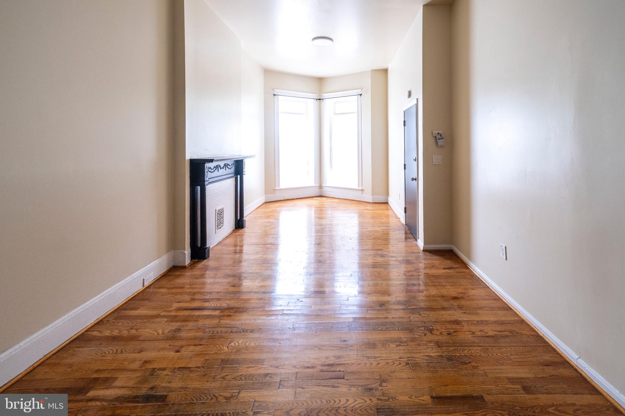 812 Newington Avenue Baltimore, MD 21217 - Photo 5 of 38 a view of an empty room with wooden floor and a window