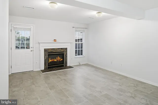 a view of an empty room with a fireplace and a window