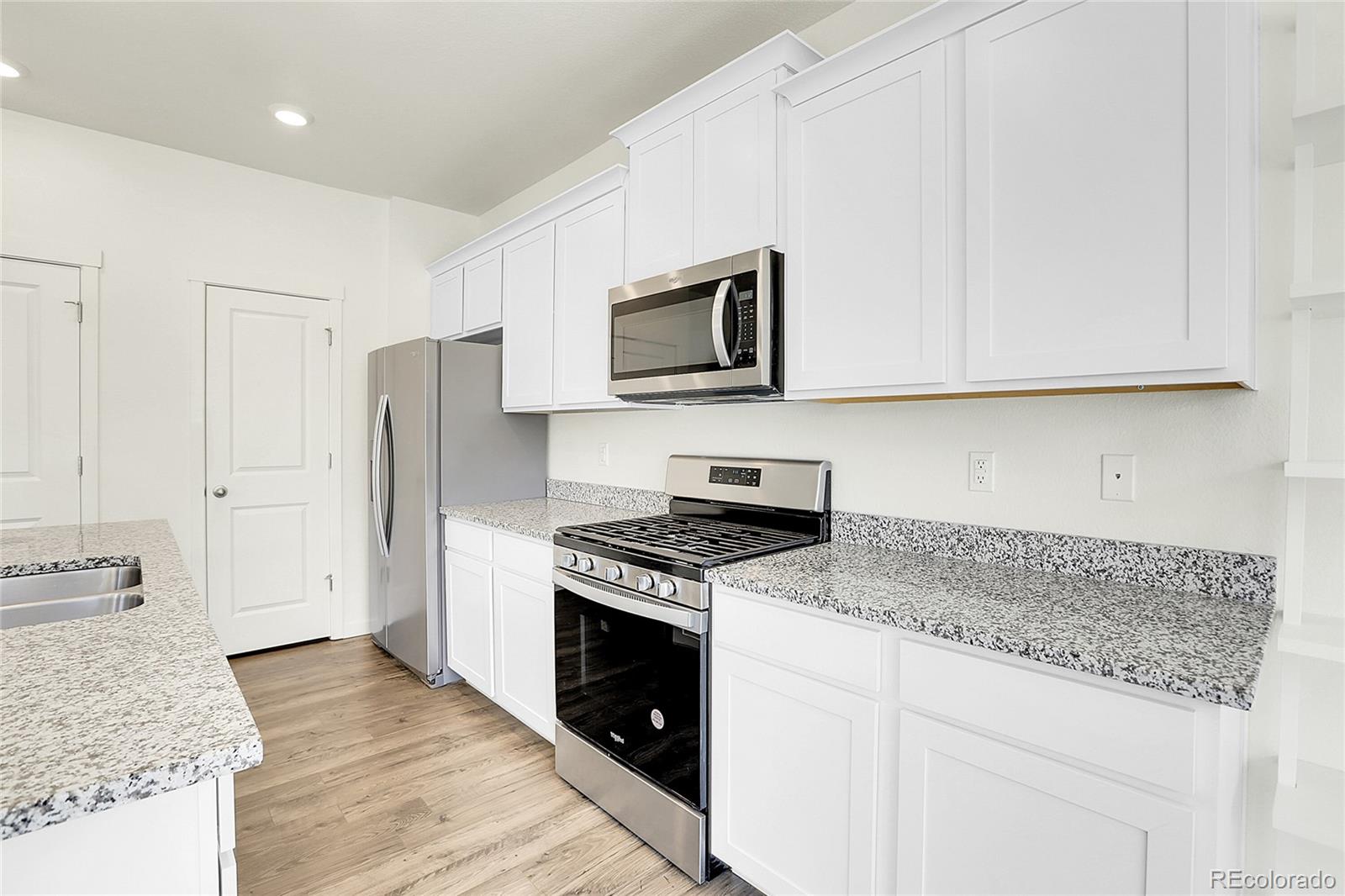 45840 Laceleaf Drive Bennett, CO 80102 - Photo 15 of 43 a kitchen with granite countertop cabinets stainless steel appliances and a counter space