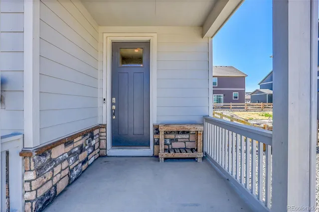 a view of a porch with two chairs and a gate
