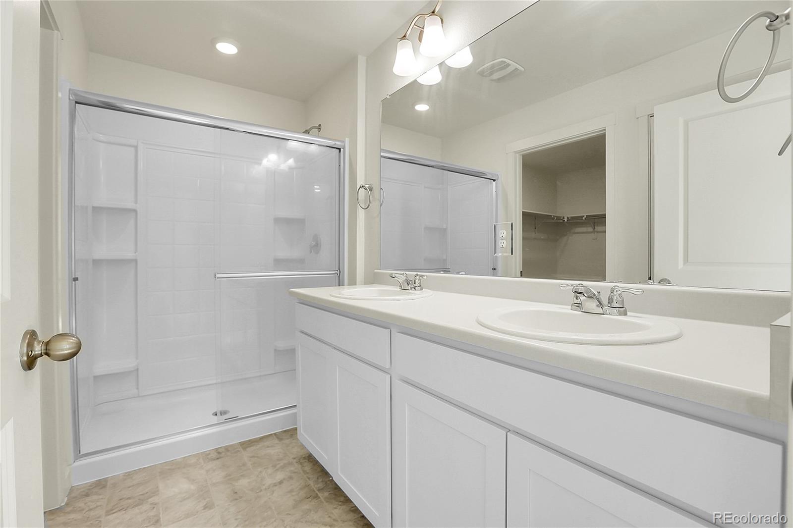 45840 Laceleaf Drive Bennett, CO 80102 - Photo 28 of 43 a bathroom with a shower sink and mirror