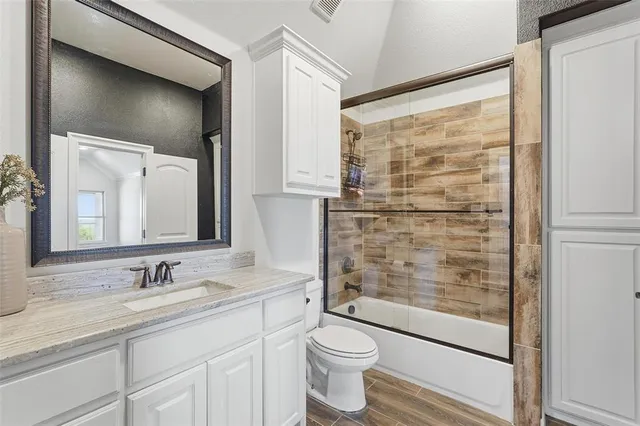 a bathroom with a granite countertop sink toilet and shower