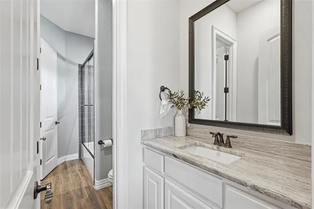a bathroom with a granite countertop sink and a mirror