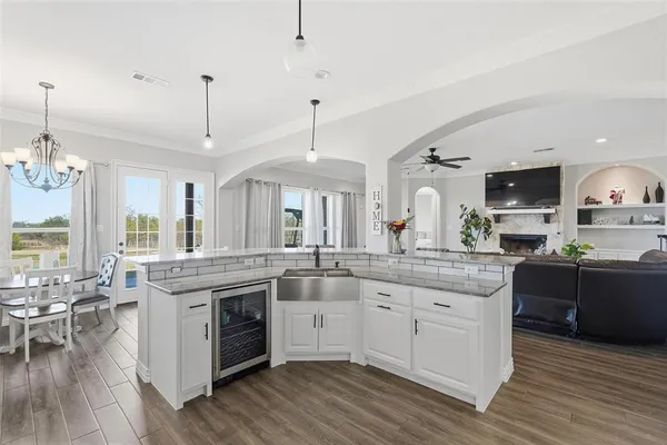 a kitchen with stainless steel appliances granite countertop hardwood floor sink stove dining table and chairs