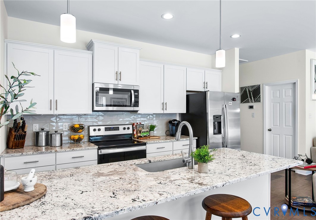6549 Bolles Landing Court Chester, VA 23831 - Photo 12 of 22 a kitchen with stainless steel appliances granite countertop a sink a stove a refrigerator and a dining table with wooden floor