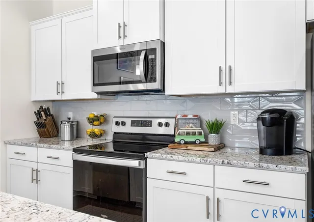 a kitchen with granite countertop white cabinets and appliances