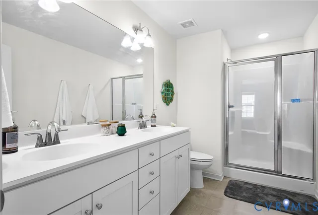a bathroom with a double vanity sink toilet and shower