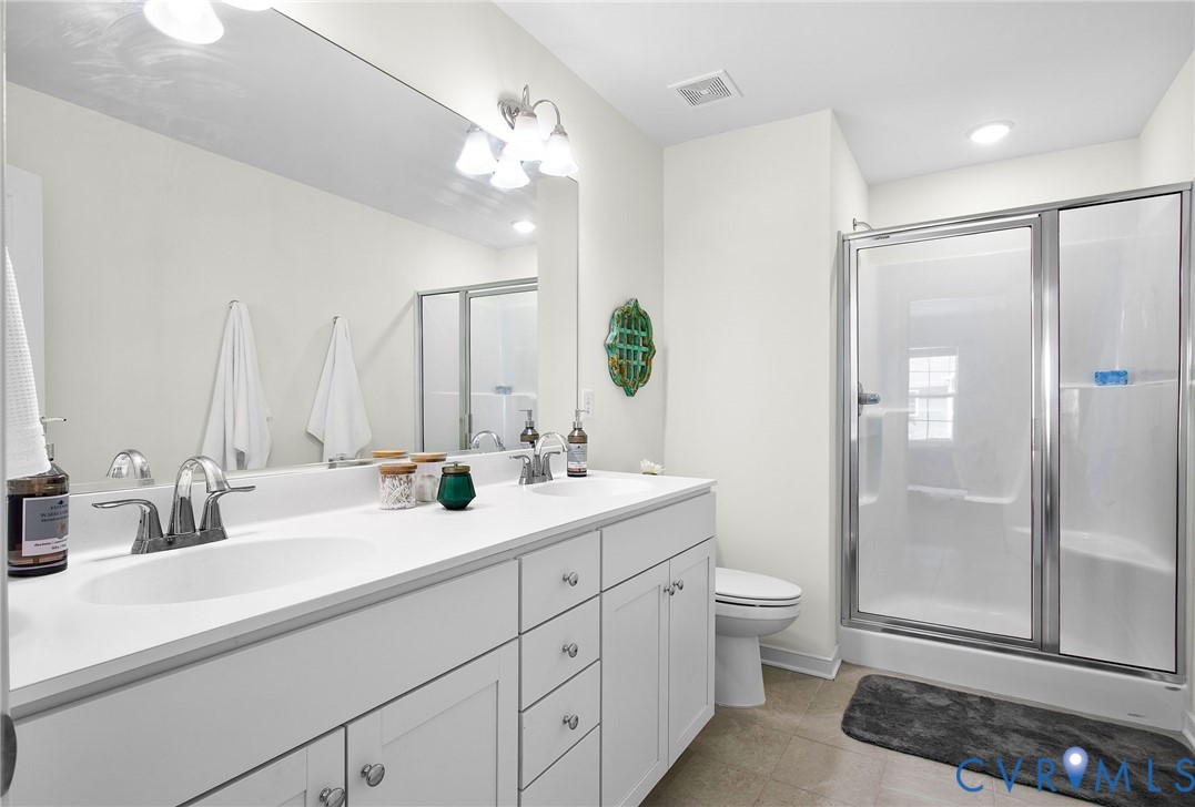 6549 Bolles Landing Court Chester, VA 23831 - Photo 16 of 22 a bathroom with a double vanity sink toilet and shower