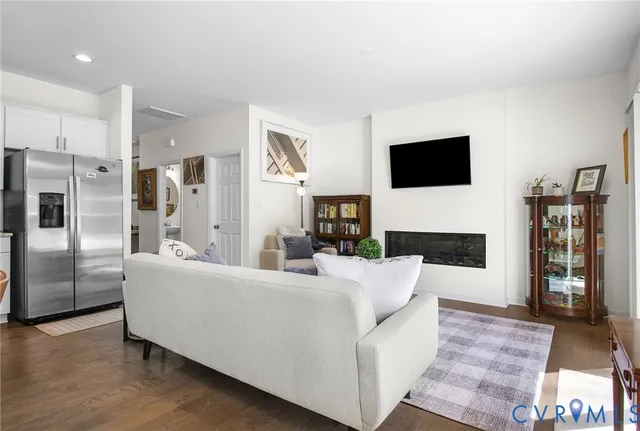 a living room with furniture a flat screen tv and a fireplace