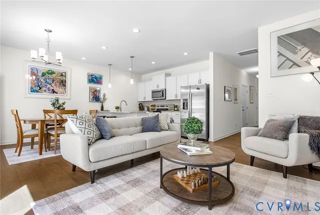 a living room with furniture and a dining table with kitchen view