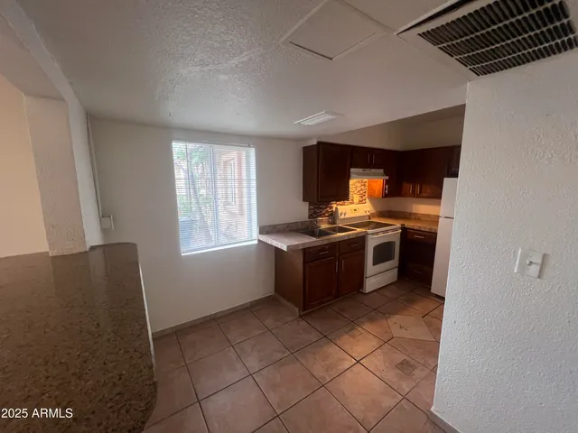 a kitchen with stainless steel appliances granite countertop a stove a sink and a refrigerator