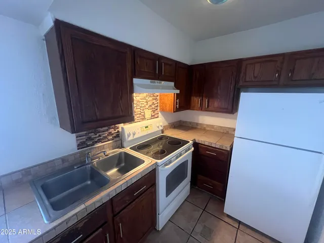 a kitchen with a refrigerator sink and cabinets