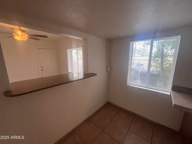 a view of a hallway with wooden floor and a bathroom