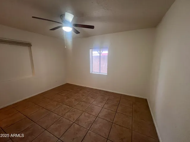 an empty room with windows and fan