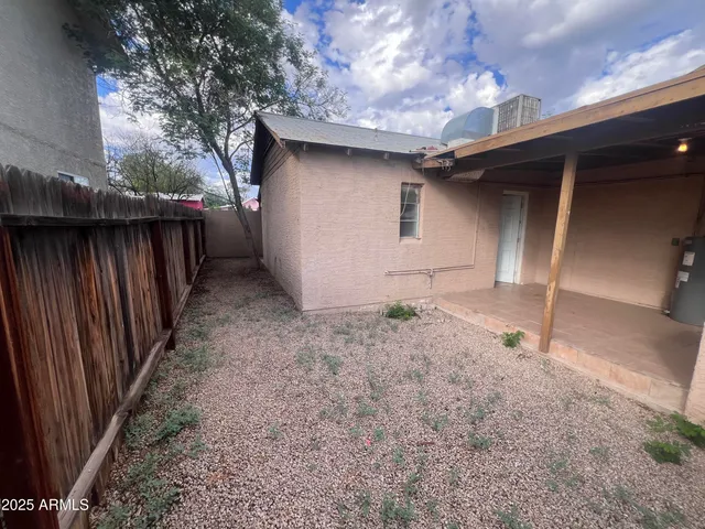 a view of a pathway of a house with wooden fence