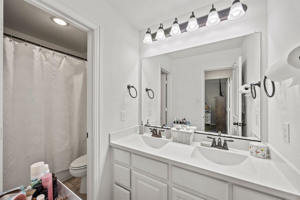 813 Pier Street Little Elm, TX 76227 - Photo 14 of 16 a bathroom with a double vanity sink mirror and toilet