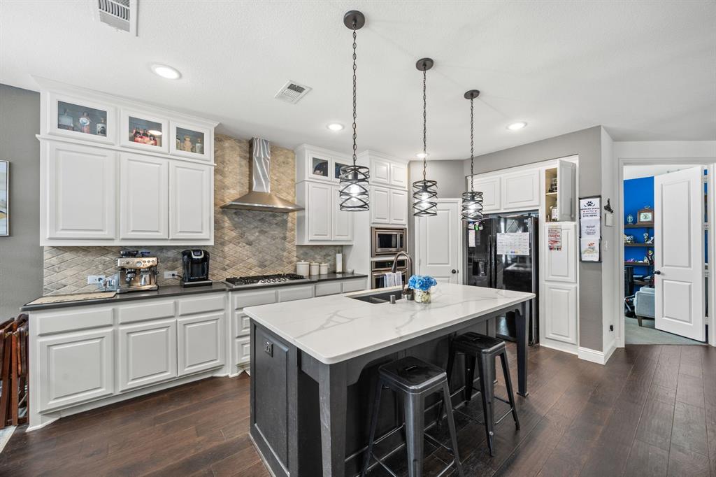 813 Pier Street Little Elm, TX 76227 - Photo 4 of 16 a kitchen with refrigerator cabinets and wooden floor