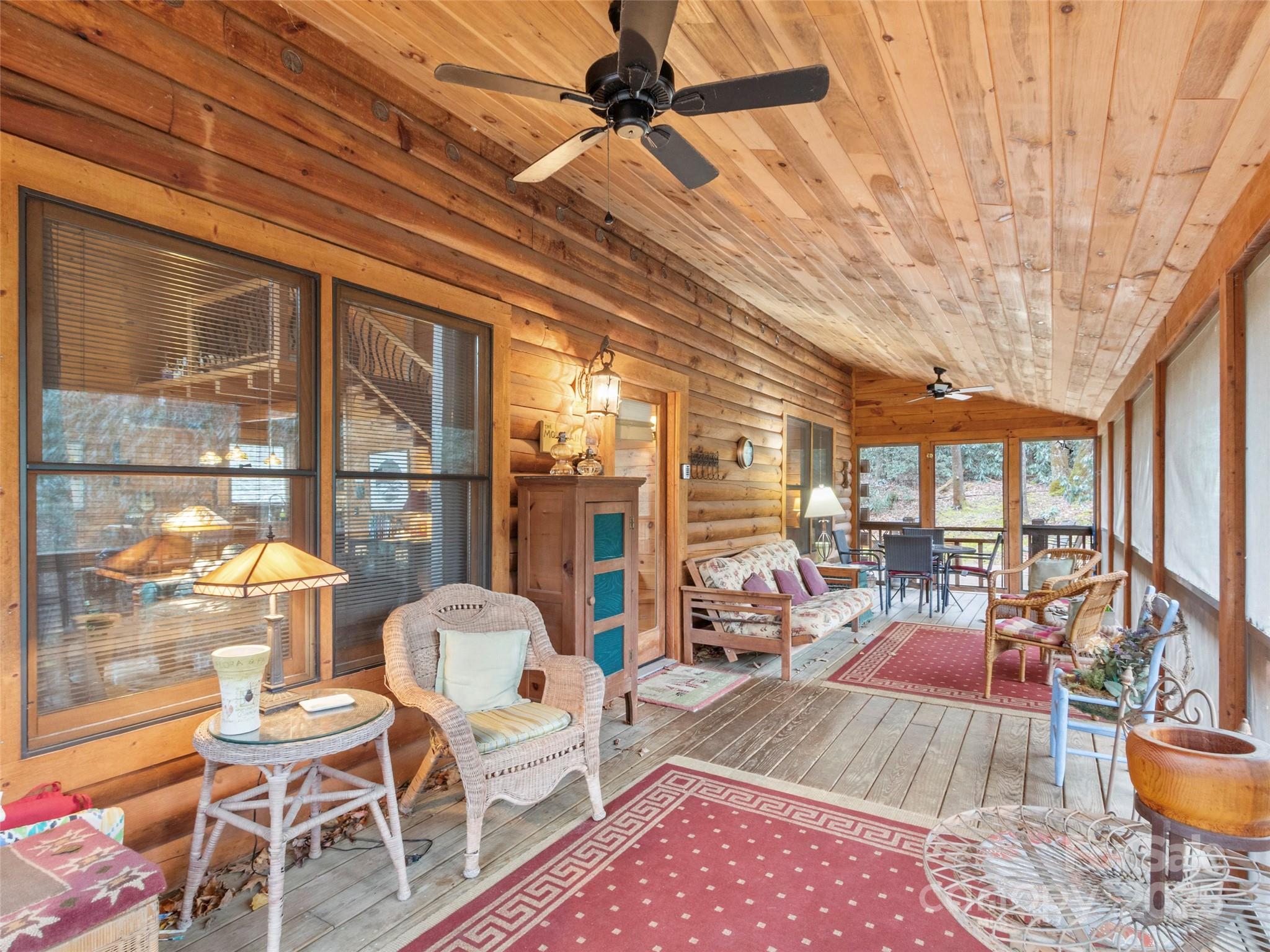 741 South Toe River Road Burnsville, NC 28714 - Photo 16 of 41 a living room with furniture a rug potted plant and a large window
