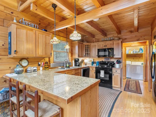 a kitchen with stainless steel appliances granite countertop a sink a stove and a wooden cabinets
