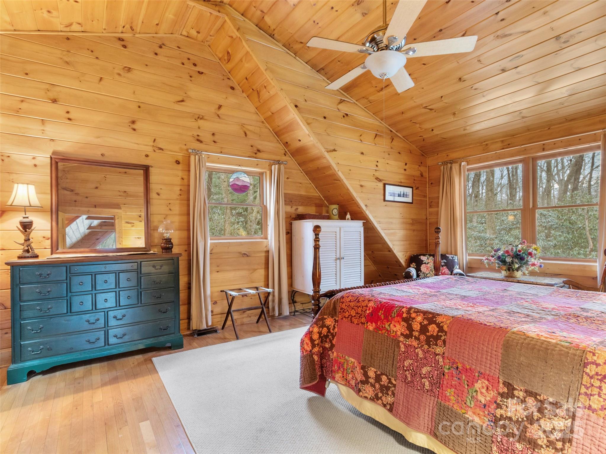741 South Toe River Road Burnsville, NC 28714 - Photo 33 of 41 a bedroom with a large bed and a chandelier