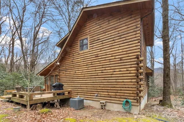 a view of backyard of house with a barbeque and wooden fence